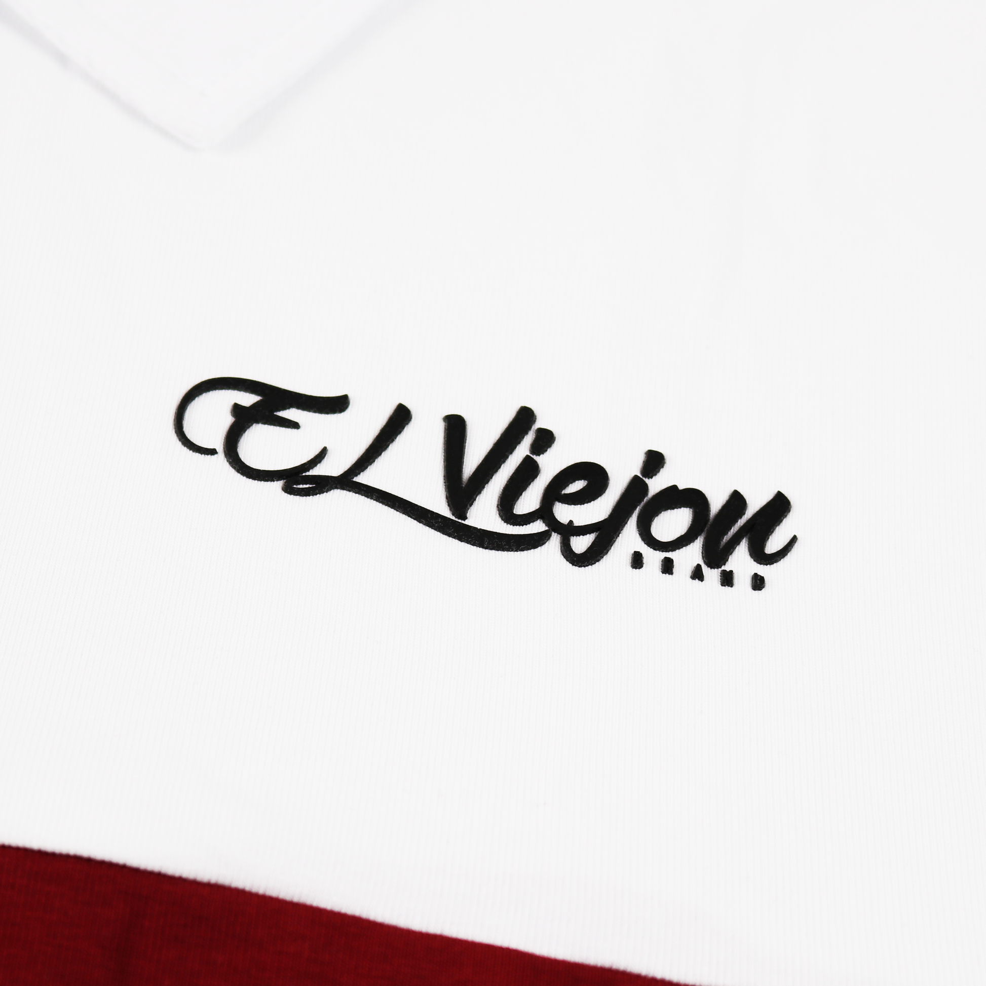 White and maroon polo shirt with a black 3D vinyl "El Viejon Brand" logo.