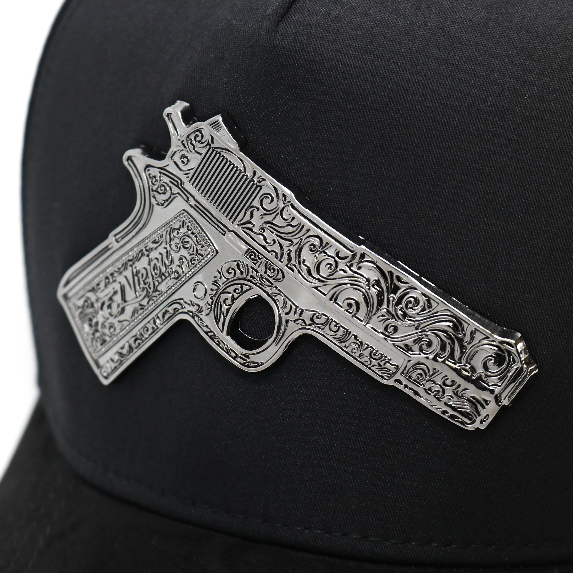 Decorative gun emblem on a black cap