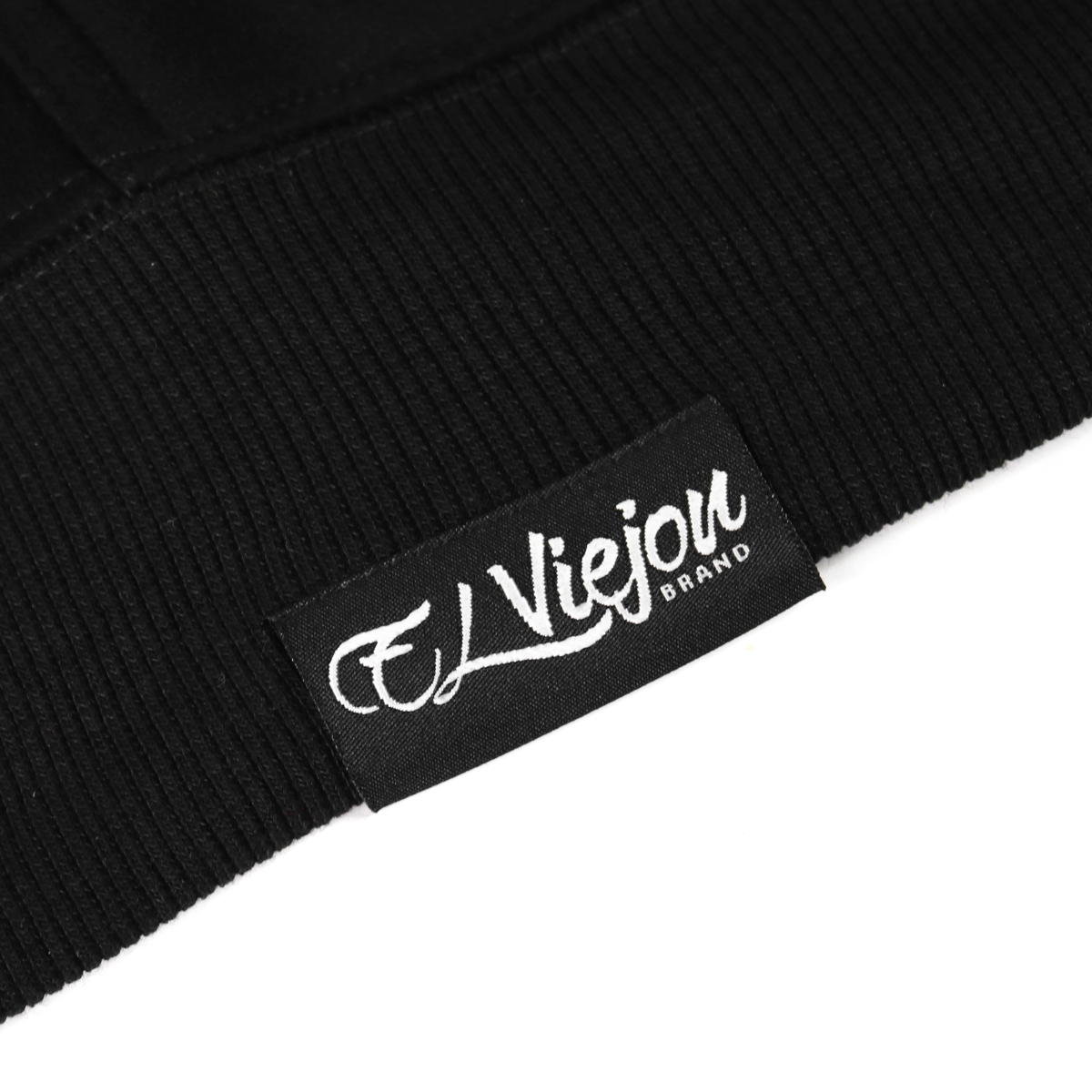 Close-up of a black cotton/poly fleece hoodie with a white "El Viejou Brand" woven label.